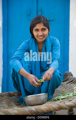 Porträt eines Mädchens Beschuss grüne Erbsen, Farrukh Nagar, Gurgaon, Haryana, Indien Stockfoto