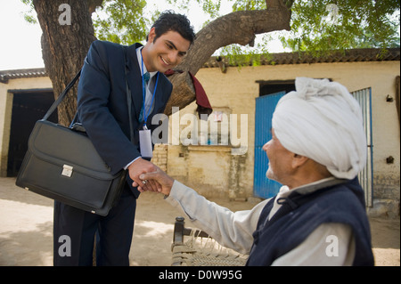 Finanzberater Händeschütteln mit einem Landwirt, Hasanpur, Haryana, Indien Stockfoto