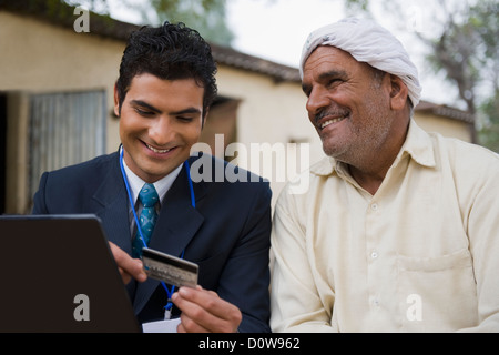 Finanzberater, lächelnd mit einem Landwirt, Hasanpur, Haryana, Indien Stockfoto