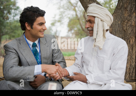 Finanzberater Händeschütteln mit einem Landwirt, Hasanpur, Haryana, Indien Stockfoto