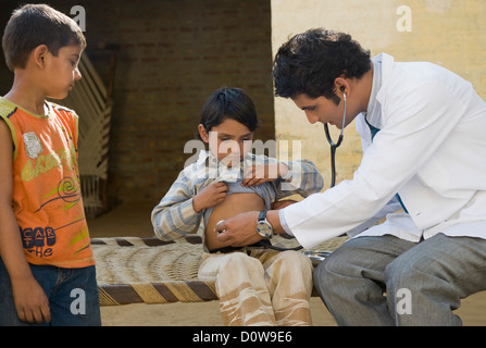 Arzt untersucht ein Junge mit einem Stethoskop, Hasanpur, Haryana, Indien Stockfoto