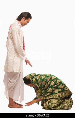 Seitenansicht einer Frau berühren die Füße ihres Ehemannes auf Bihu festival Stockfoto