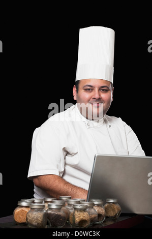 Koch mit einem Laptop und verschiedene Gewürze Stockfoto