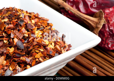 Grob gemahlener roter Pfeffer und ganze getrocknete Paprika. Stockfoto