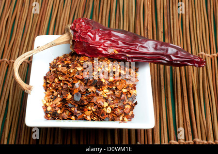 Grob gemahlener roter Pfeffer und ganze getrocknete Paprika. Stockfoto