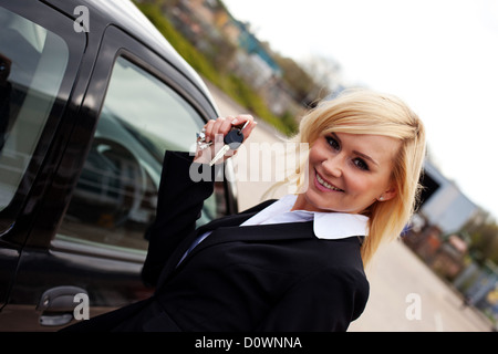 Lächelnde Blondine mit Autoschlüssel Stockfoto