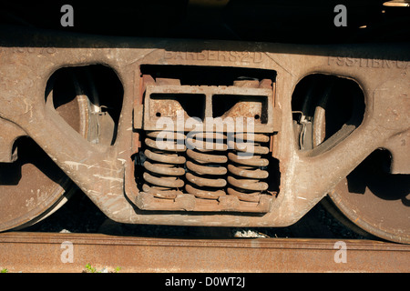 Räder und Frühling auf dem Fahrgestell ein Eisenbahnwaggon beruhen auf eine wenig befahrene Strecke. Stockfoto