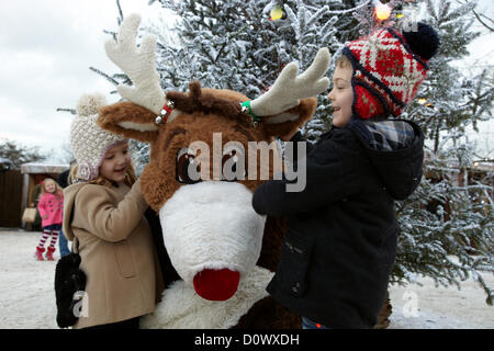 Kinder treffen im Elf-Dorf auf Rentierfiguren. Lappland, Großbritannien, Bewl Water, Kent, 1. Dezember 2012. Stockfoto