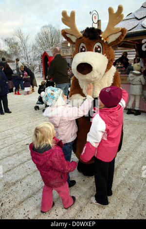 Kinder treffen im Elf-Dorf auf Rentierfiguren. Lappland, Großbritannien, Bewl Water, Kent, 1. Dezember 2012. Stockfoto