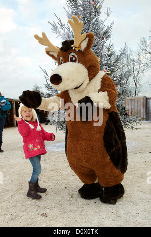 Kinder treffen im Elf-Dorf auf Rentierfiguren. Lappland, Großbritannien, Bewl Water, Kent, 1. Dezember 2012. Stockfoto