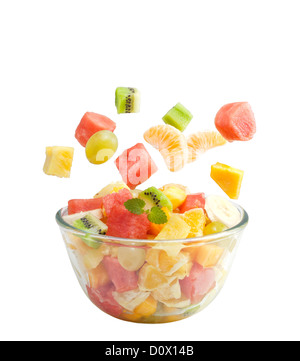 Obst Salat fliegt in die Schüssel isoliert auf weißem Hintergrund Stockfoto