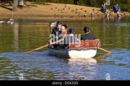 4 orthodoxe jüdische Männer in einem Ruderboot, hohlen Teiche, Leytonstone, London, England Stockfoto