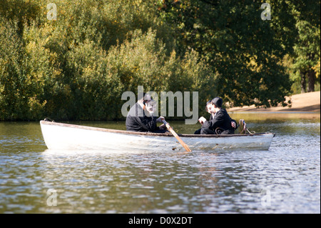 Orthodoxen jüdischen Mann mit einem Mobiltelefon in einem Ruderboot, hohlen Teiche, Leytonstone, London, England Stockfoto