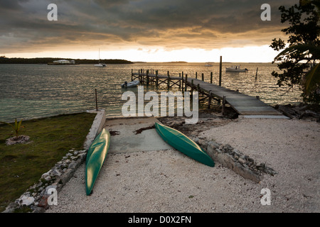 Zwei Kajaks bereit für morgen. Zwei grüne Kajaks am Strand aufgestellt, während die Sonne über dem Hafen von Hopetown untergeht. Stockfoto