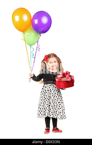 In voller Länge Portrait eines lächelnden Mädchens hält ein Geschenk und Haufen Luftballons isoliert auf weißem Hintergrund Stockfoto
