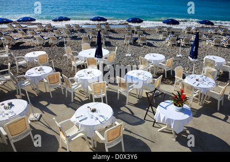 Tischen und Stühlen und Sonnenliegen am Strand gesetzt, aus dem Ort Anglais, Nizza, Côte d ' Azur, Frankreich Stockfoto