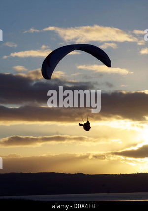 Mann-Paragliding über den Fluss Dee in Cheshire gegen die untergehende Sonne Stockfoto