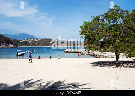 Menschen genießen die unberührte weiße sand Strand & transluzent blau des Meeres in geschützten Bucht von Playa La Entrega Huatulco, Mexiko Stockfoto