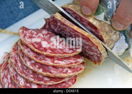 große Scheiben leckere Salami Slice mit dem Messer Stockfoto