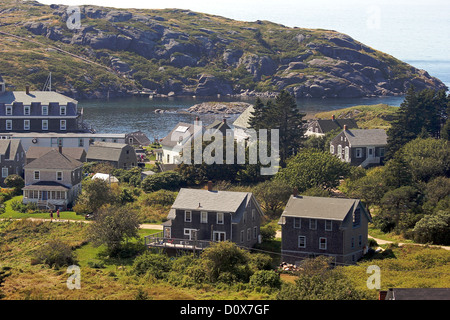 Häuser im Dorf Monhegan, Monhegan Island, Maine, mit Manana Island im Hintergrund Stockfoto