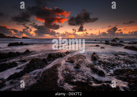 Einen feurigen Sonnenuntergang am Welcombe Mund Bay, Devon Stockfoto