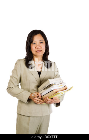 Reife Asiatin Lehrer halten Stapel von Büchern und Gläser auf weißem Hintergrund Stockfoto