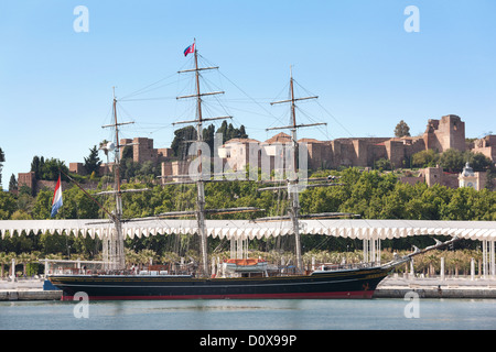 Malaga Alcazaba und moderne Hafenpromenade Palmeral de las Sorpresas mit Clipper Stad Amsterdam Segelschiff Málaga Stockfoto