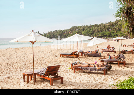 Sonnenschirme und Liegestühle am Pansea Beach, in der Nähe von Surin Beach, Phuket, Thailand Stockfoto