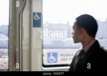 Geschäftsmann in einem Zug Blick durch Fenster Stockfoto