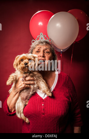 Ältere Frau Hund halten und trägt eine tiara Stockfoto