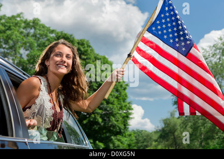 Teenager-Mädchen aus amerikanischen Flagge Autofenster gelehnt Stockfoto