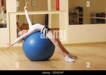 Kleine Turnerin Verlegung auf Kugel Stockfoto