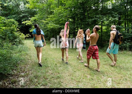 Fünf Freunde, die zu Fuß auf dem Rasen, Rückansicht Stockfoto