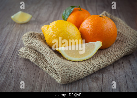 Handvoll frische rohe Zitrusfrüchte auf einem hölzernen Hintergrund Stockfoto