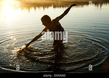 Frau berühren Wasser im See Stockfoto