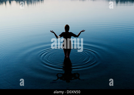 Frau, meditieren im friedlichen See Stockfoto