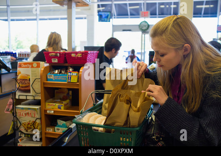 Junge Frau an der Kasse im amerikanischen Supermarkt Auschecken Stockfoto