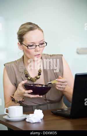 Geschäftsfrau, sitzen an einem Schreibtisch vor einem Laptop. Stockfoto
