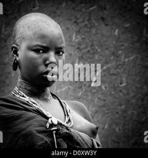 Schwarz / weiß Porträt einer jungen Uta Hamer Stamm Frau mit starken Ausdruck und rasierten Kopf, Turmi, Omo-Tal, Äthiopien Stockfoto