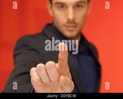 gut aussehender Mann in Anzug, die virtuelle Taste Stockfoto