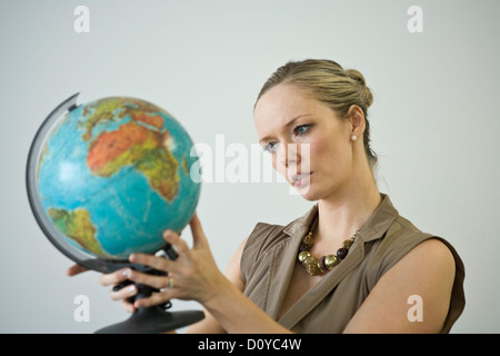 Nahaufnahme einer Geschäftsfrau, eine Welt in ihren Händen hält. Stockfoto