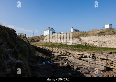 Wachturm und Hütten und einer Bank an der Küste bei Seaton Schleuse Northumberland, England UK Stockfoto