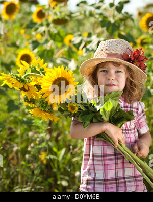 Kind mit Haufen von Sonnenblumen Stockfoto