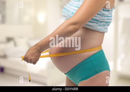 Schwangere Frau misst ihren Bauch. Stockfoto