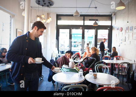 Salusbury Reformhäuser, NW6 Salusbury Road, London, UK. 04.12.2012 Bild zeigt Robert Claassen, der Besitzer eines einsamen Food Shop und Coffee-Shop, erschienen auf ITV News und erklärte, dass er "wütend", dass er bezahlt mehr Körperschaftsteuer als Starbucks, eröffnet ein Geschäft genau gegenüber in der High Street von seiner Nahrung, speichern Räumlichkeiten. Seine Kommentare kamen nach der Kanzler enthüllt eine £ 154 Millionen Blitz auf namhafte global agierende Unternehmen und vermögende Privatpersonen, die Steuerbescheide, Klaue wieder Milliarden von Pfund für den Fiskus ausweichen. Stockfoto