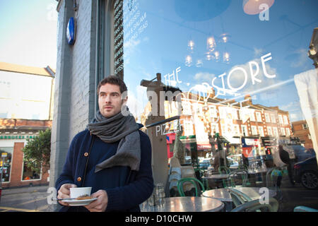 Salusbury Reformhäuser, NW6 Salusbury Road, London, UK. 04.12.2012 Bild zeigt Robert Claassen, der Besitzer eines einsamen Food Shop und Coffee-Shop, erschienen auf ITV News und erklärte, dass er "wütend", dass er bezahlt mehr Körperschaftsteuer als Starbucks, eröffnet ein Geschäft genau gegenüber in der High Street von seiner Nahrung, speichern Räumlichkeiten. Seine Kommentare kamen nach der Kanzler enthüllt eine £ 154 Millionen Blitz auf namhafte global agierende Unternehmen und vermögende Privatpersonen, die Steuerbescheide, Klaue wieder Milliarden von Pfund für den Fiskus ausweichen. Stockfoto