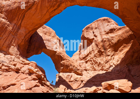 Wanderer-Stand in den Torbogen im Double Arch Arches National Park in der Nähe von Moab, Utah Vereinigte Staaten von Amerika, USA Stockfoto