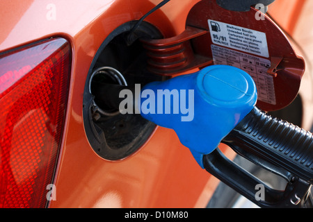 orangene Auto an Tankstelle mit Kraftstoff gefüllt Stockfoto