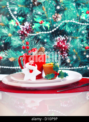 Bild von Weihnachten Tischdekoration, Weihnachtszeit Stillleben über wunderschön geschmückter Weihnachtsbaum Hintergrund Stockfoto