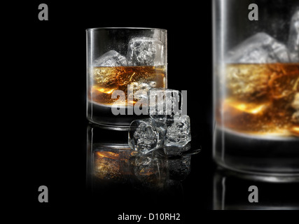 "on the Rocks" kurze Glas mit Eis und Whisky trinken, Wasser Tropfen auf gekühltes Glas Whiskey platziert auf einem schwarzen Hintergrund Stockfoto